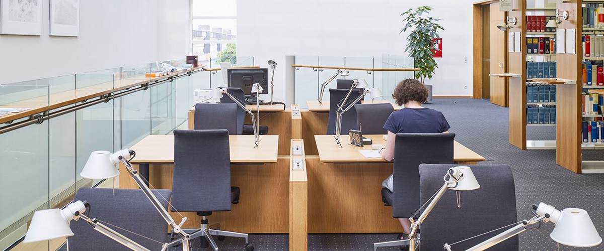 Lesebereich der Bibliothek mit Frau am Tisch